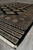 Load image into Gallery viewer, Patterned black and beige rug on a wooden floor