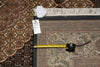 Load image into Gallery viewer, Measuring tape and small object on a patterned rug with a visible brand label.
