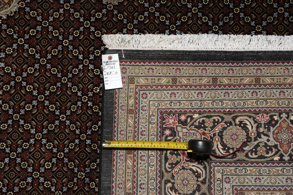 Patterned rug with a measuring tape and a small object on top, against a dark textured background.