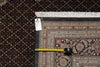 Load image into Gallery viewer, Patterned rug with a measuring tape and a small object on top, against a dark textured background.