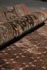 Load image into Gallery viewer, Roll of patterned rug with intricate designs on a dark surface