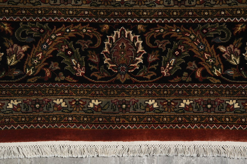 Close-up of a patterned rug with intricate designs and fringes.