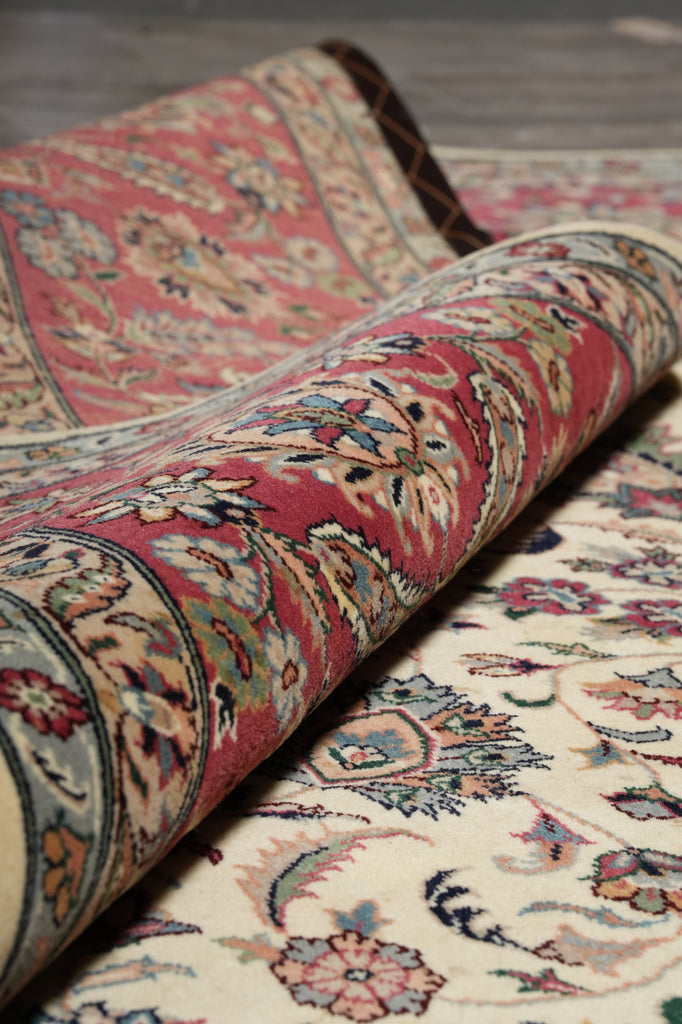 Rolling up a patterned rug on a wooden floor