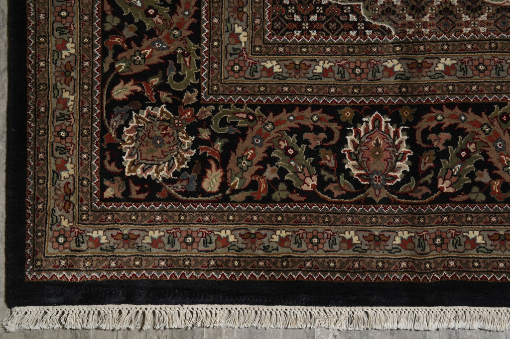 Close-up of an ornate rug with intricate patterns and fringes on a plain background