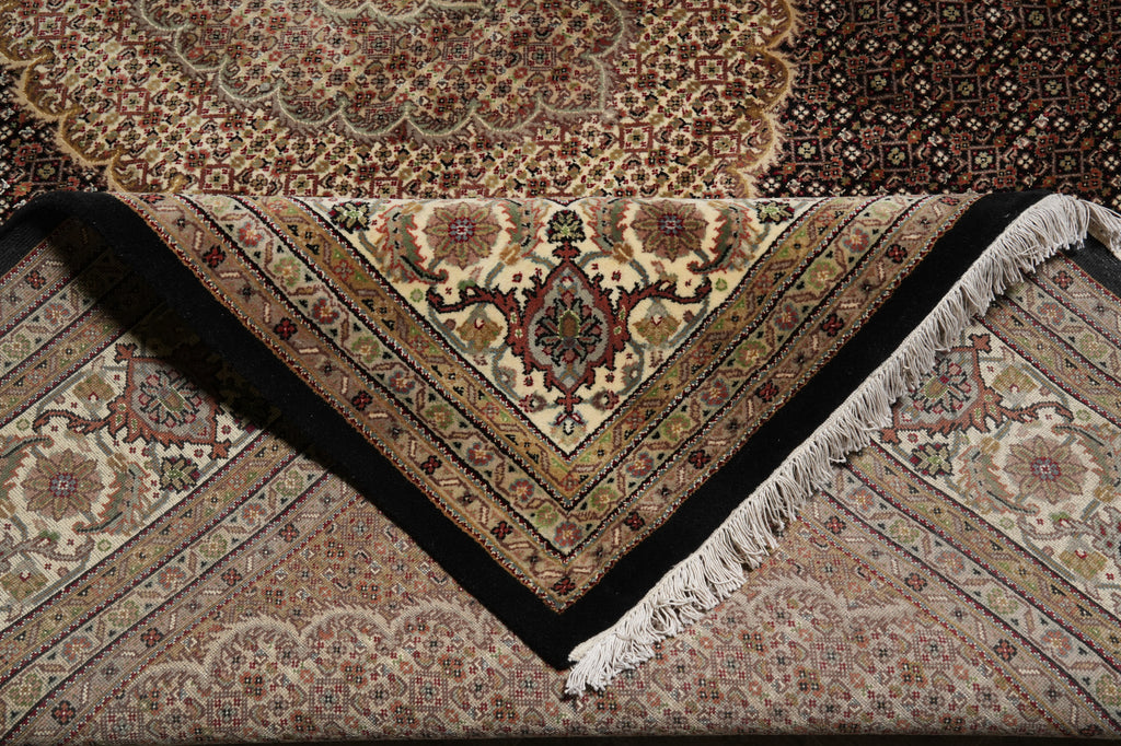 Close-up of a patterned rug with intricate designs and fringes.
