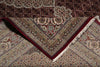 Load image into Gallery viewer, Close-up of a patterned rug with intricate designs and red border.