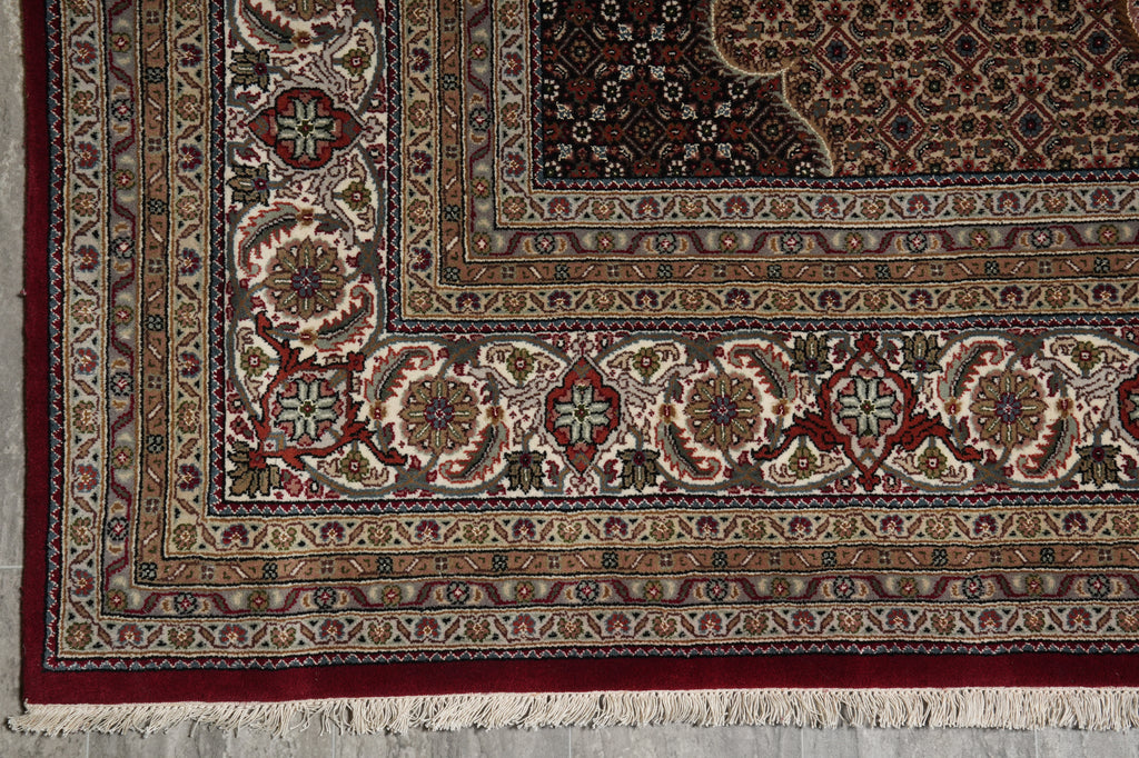 Close-up of a patterned rug with intricate designs and fringes.