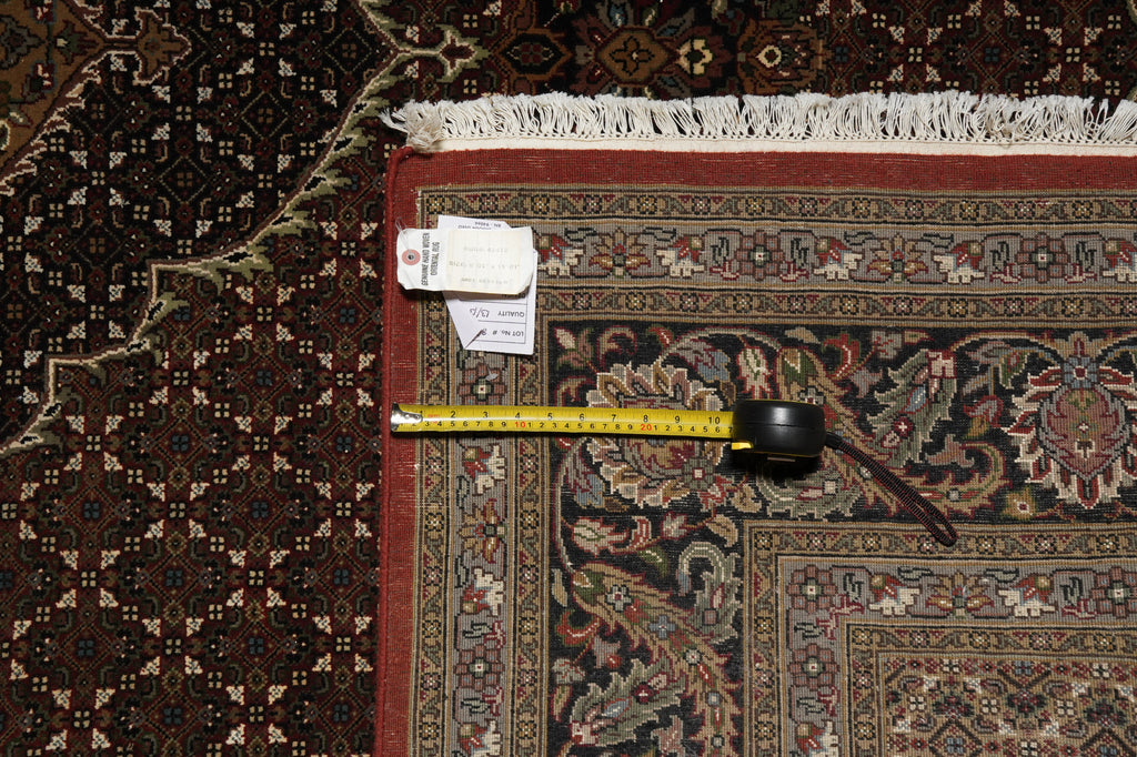 Decorative rug with a measuring tape and a tag on it, placed on another rug.