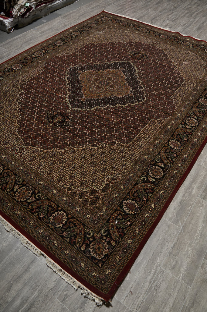 Decorative brown rug with intricate patterns on a gray floor.