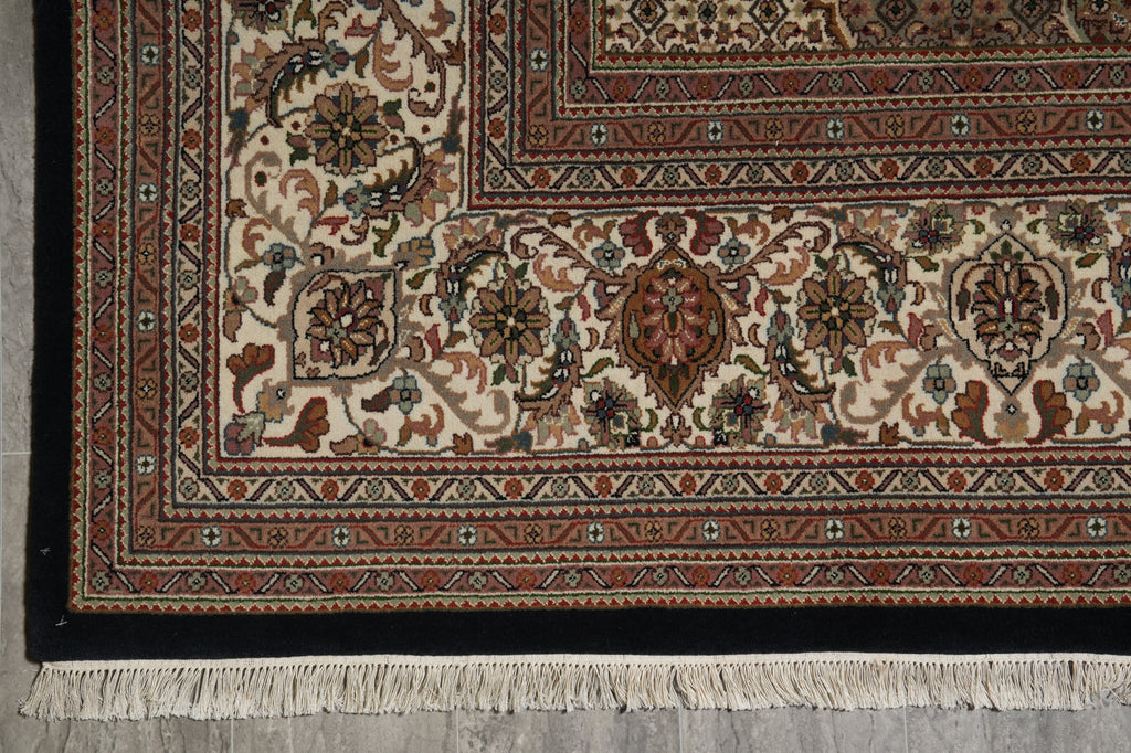 Close-up of a patterned rug with intricate designs on a gray floor.