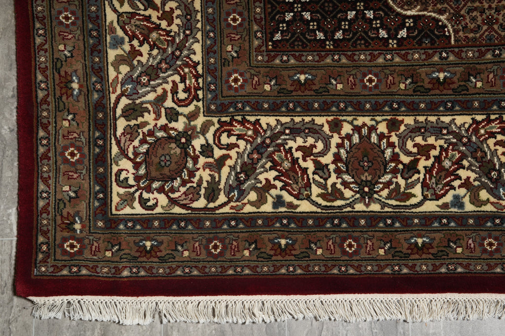 Close-up of an ornate rug with intricate patterns on a concrete floor.