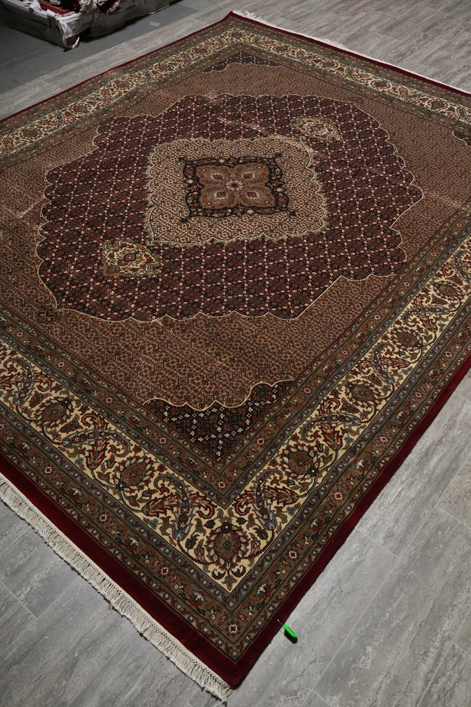 Decorative brown rug with intricate patterns on a gray floor.