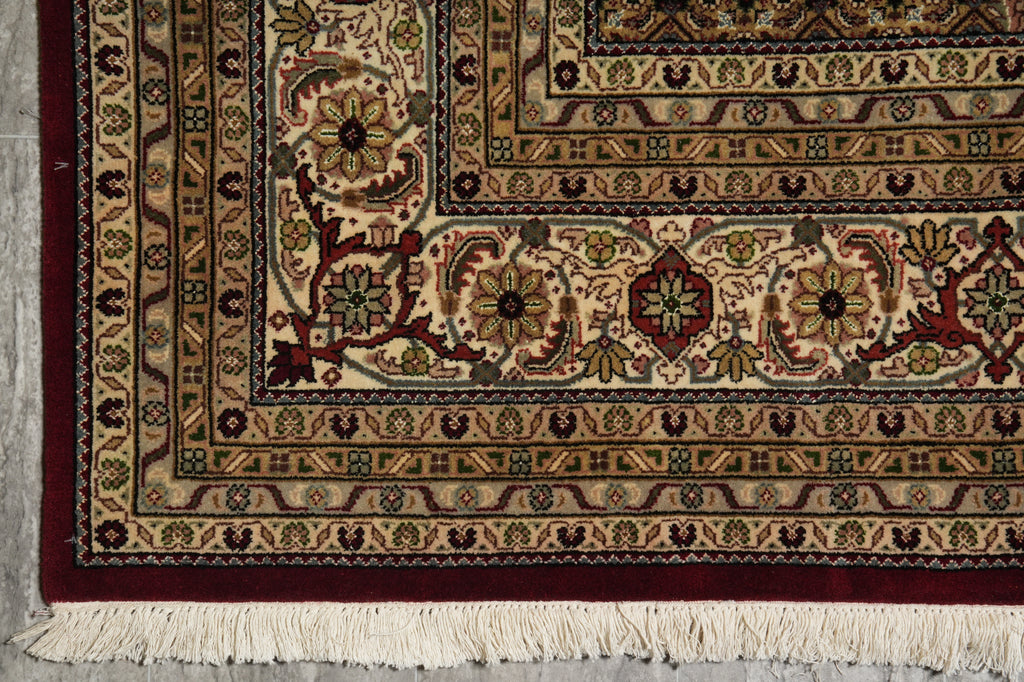 Close-up of a patterned rug with intricate designs on a gray floor.