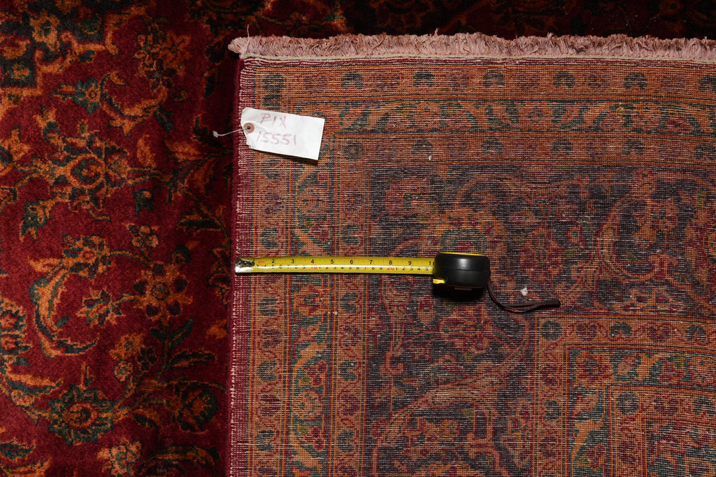 Patterned rug with a measuring tape and price tag on a dark background