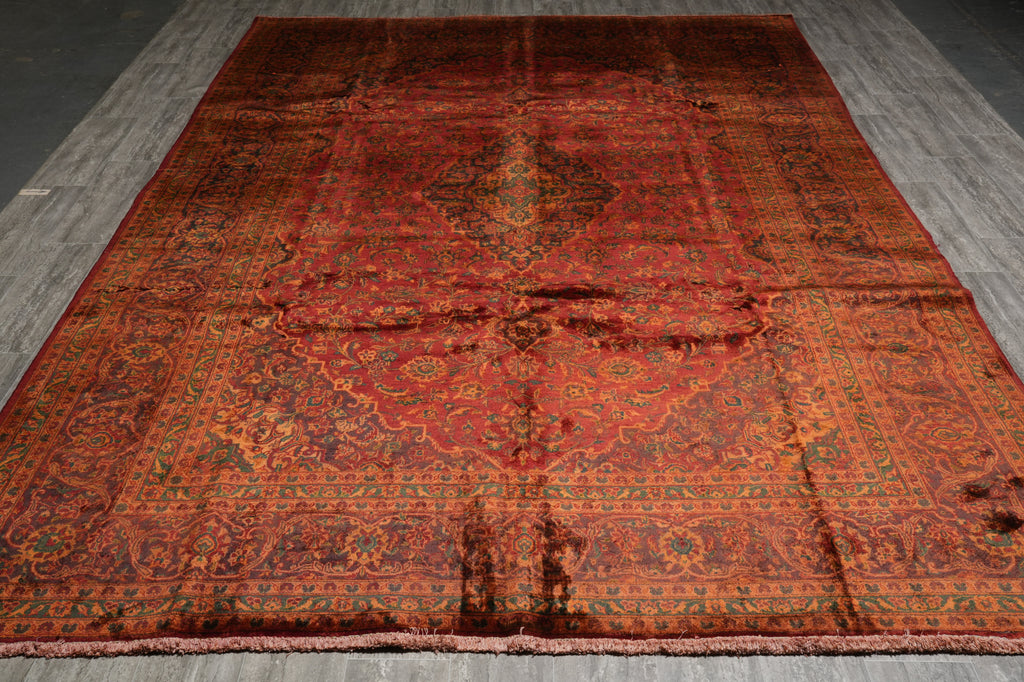Decorative red and orange patterned rug on a wooden floor