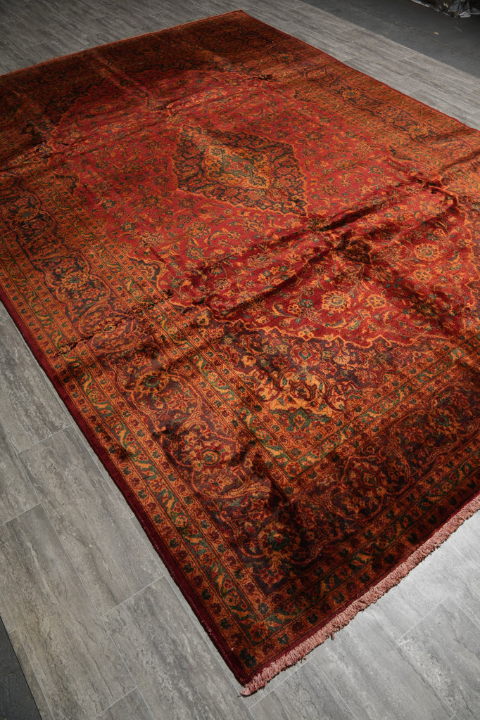 Decorative red and orange patterned rug on a wooden floor