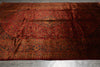 Load image into Gallery viewer, Vintage red rug with intricate patterns on a wooden floor.