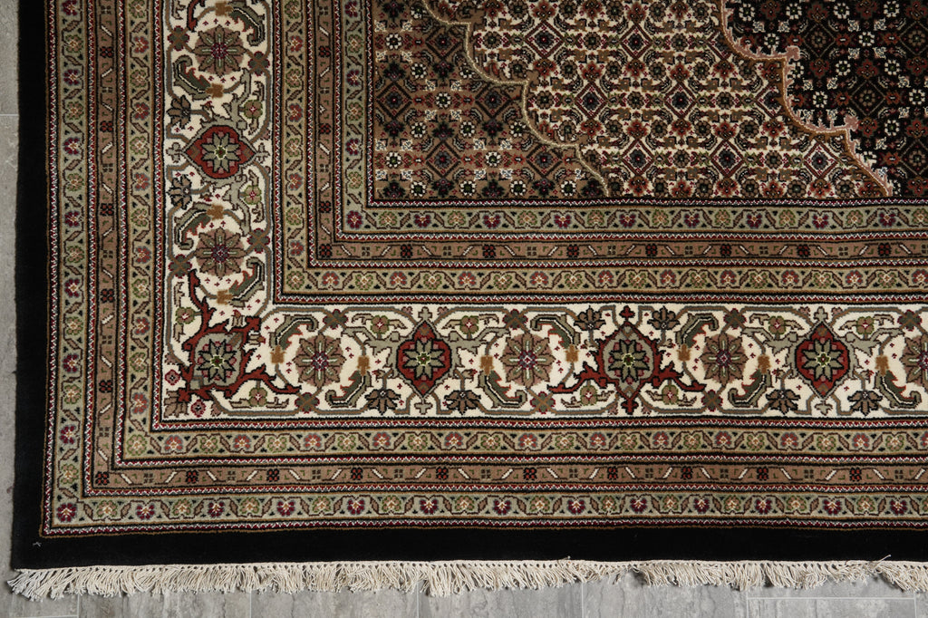 Close-up of an ornate rug with intricate patterns on a gray floor.