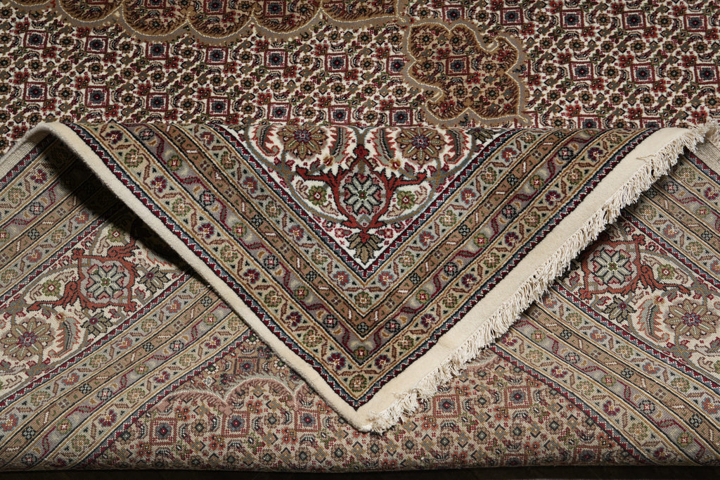 Close-up of a patterned rug with intricate designs and fringes.