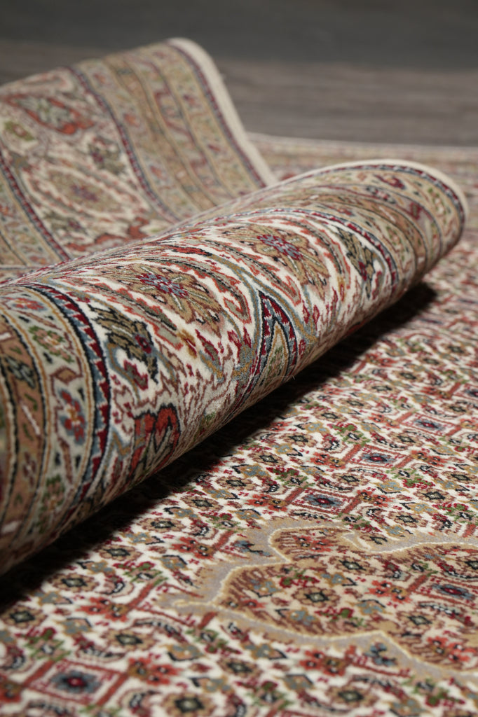 Roll of patterned carpet with intricate designs on a neutral background