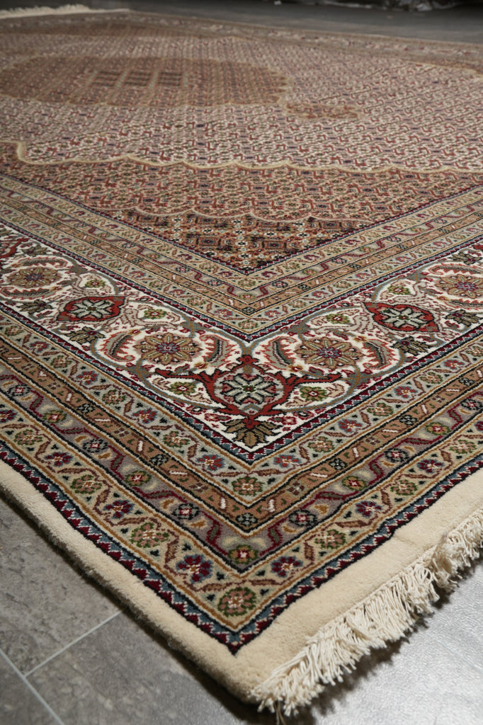 Close-up of a patterned rug with intricate designs on a tiled floor.
