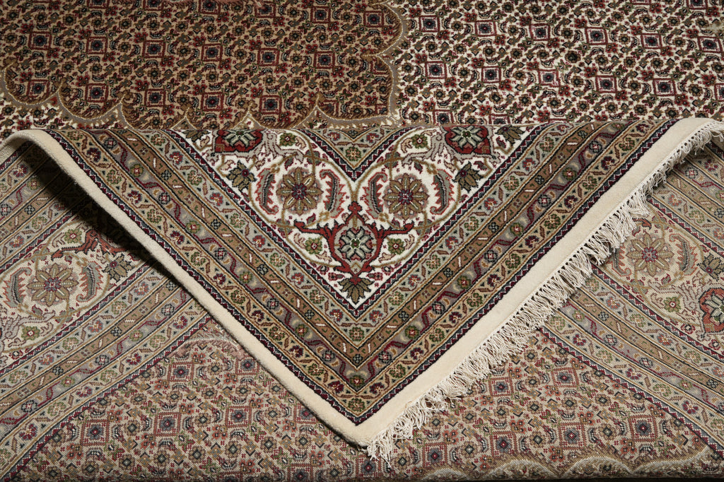 Close-up of a patterned rug with intricate designs and fringes.