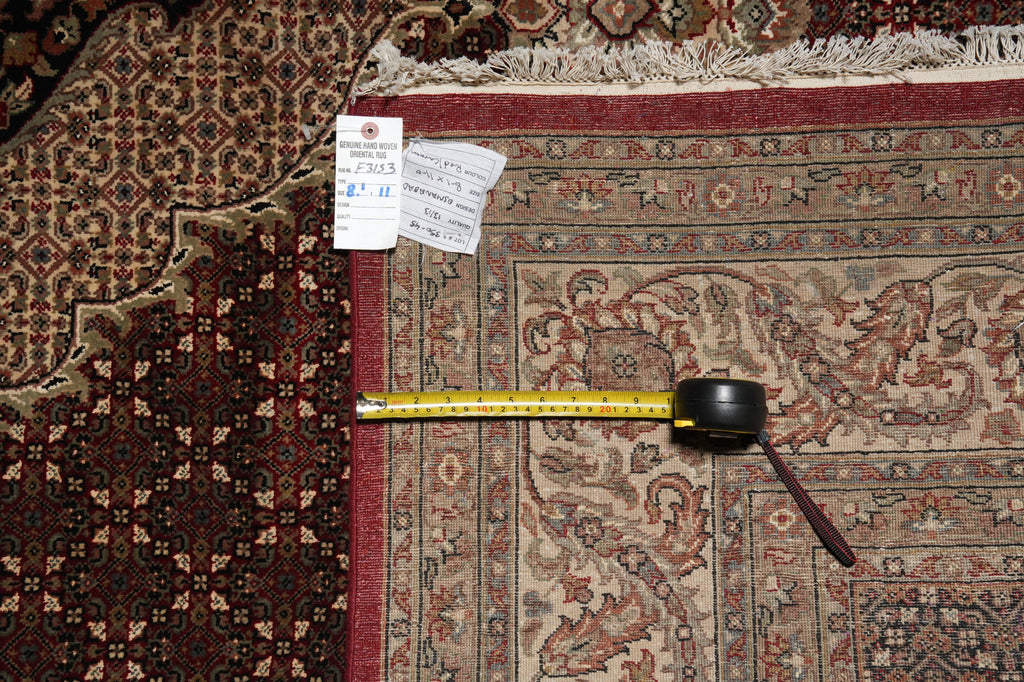 Measuring tape on a patterned rug with a visible size tag.