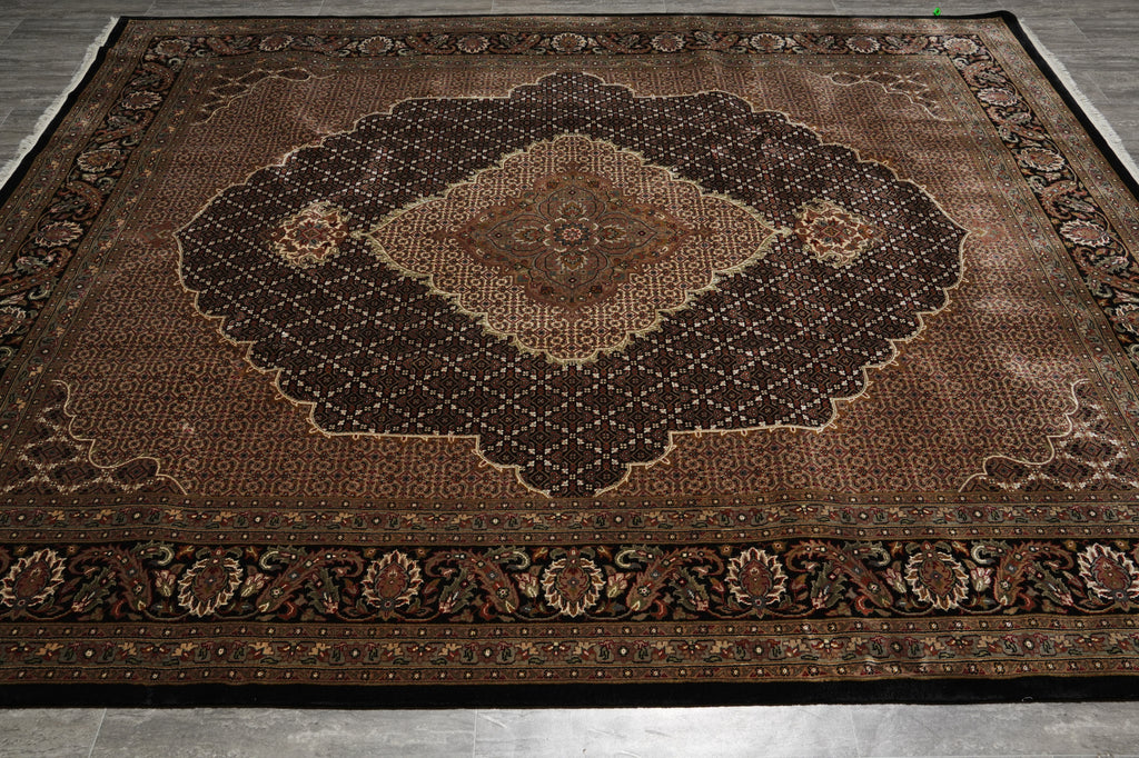Decorative brown rug with intricate patterns on a wooden floor.