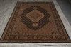 Load image into Gallery viewer, Decorative brown rug with intricate patterns on a wooden floor.