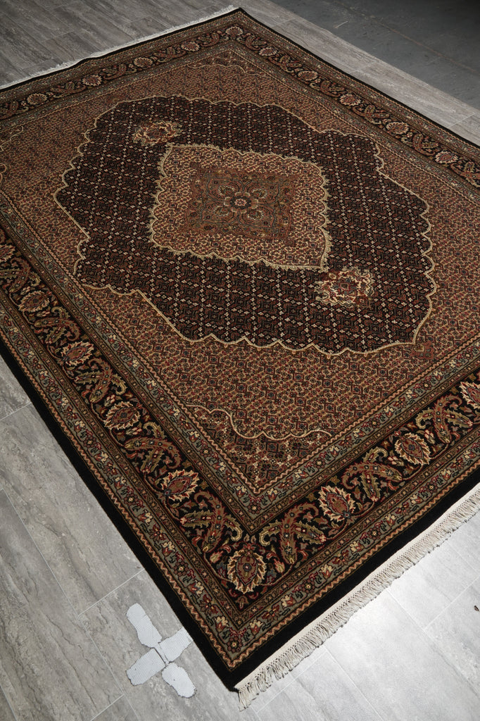 Decorative brown rug with intricate patterns on a gray floor.