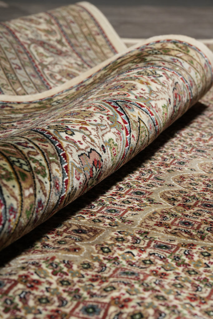 Roll of patterned fabric with intricate designs on a plain background