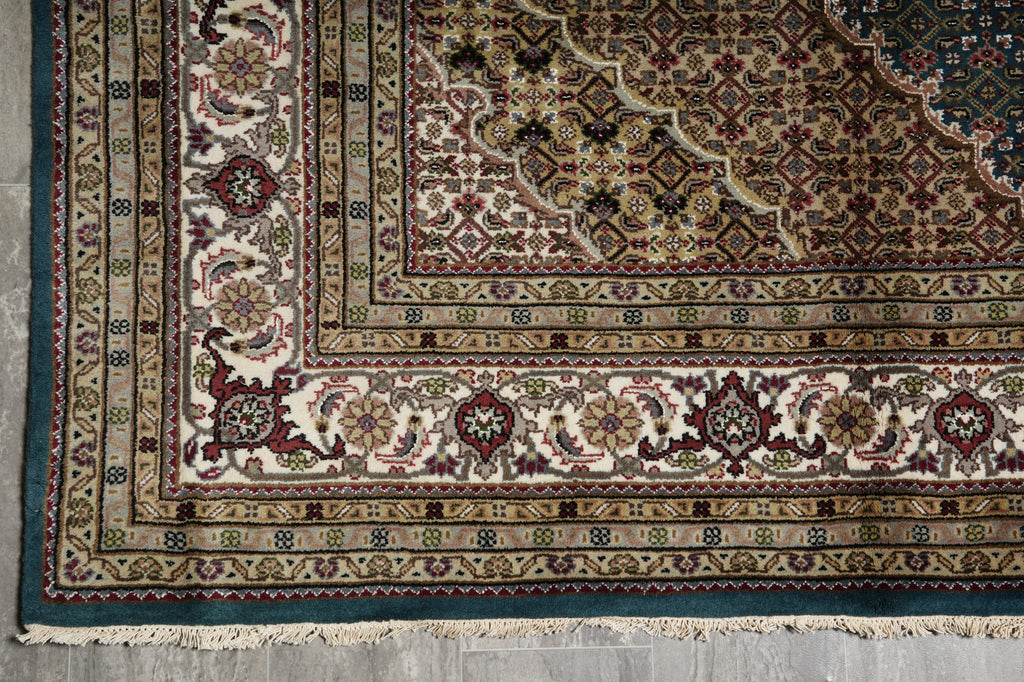 Close-up of a patterned rug with intricate designs on a concrete floor.