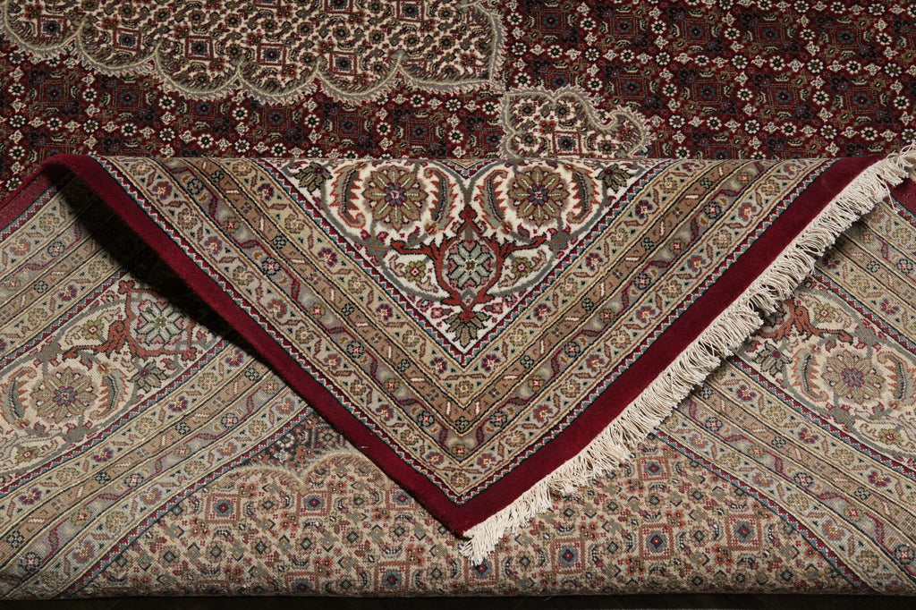 Close-up of an intricately patterned rug with a red border