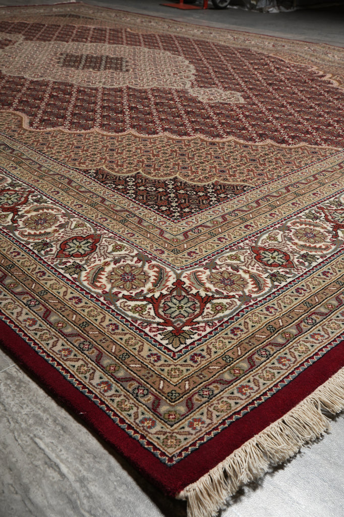 Close-up of a patterned rug with intricate designs on a textured surface.