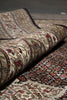Load image into Gallery viewer, Close-up of a rolled-up patterned rug with intricate designs.