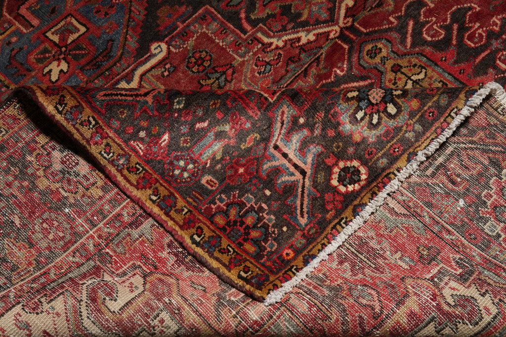 Close-up of an intricately patterned rug with red and brown colors.