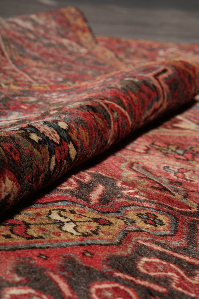 Close-up of a patterned fabric with red, brown, and gold colors.
