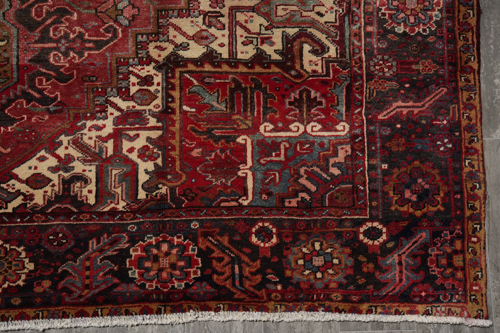 Close-up of a patterned rug with intricate designs on a gray floor.