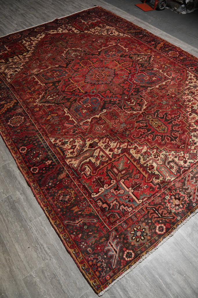 Vintage red and brown patterned rug on a gray floor