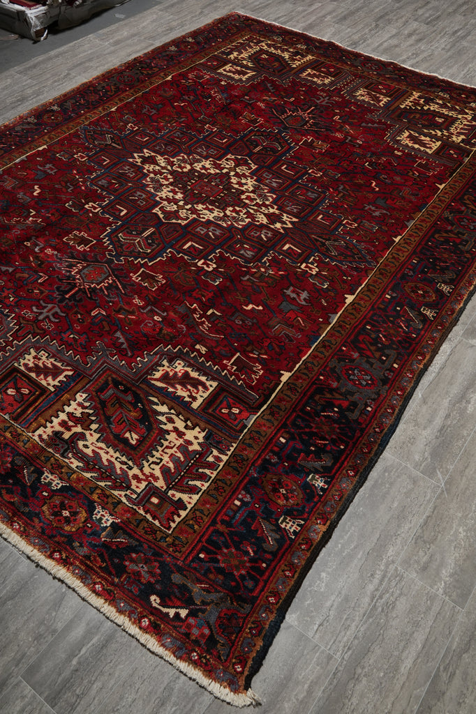 Decorative red and black patterned rug on a wooden floor
