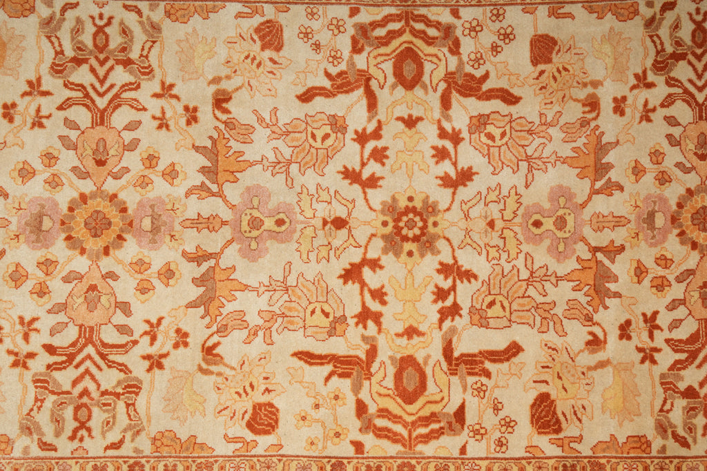 Close-up of a patterned fabric with intricate designs in orange and beige.