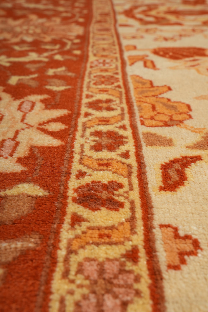 Close-up of a patterned rug with red and beige colors