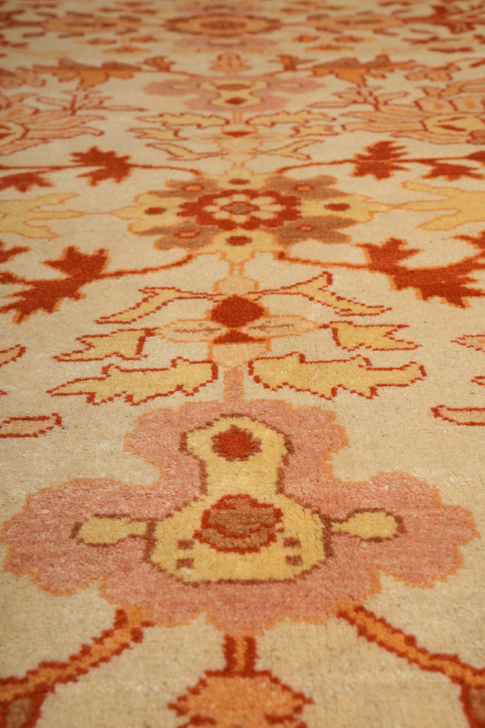 Close-up of a patterned rug with intricate designs in orange, brown, and beige.
