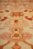 Load image into Gallery viewer, Close-up of a patterned rug with intricate designs in orange, brown, and beige.
