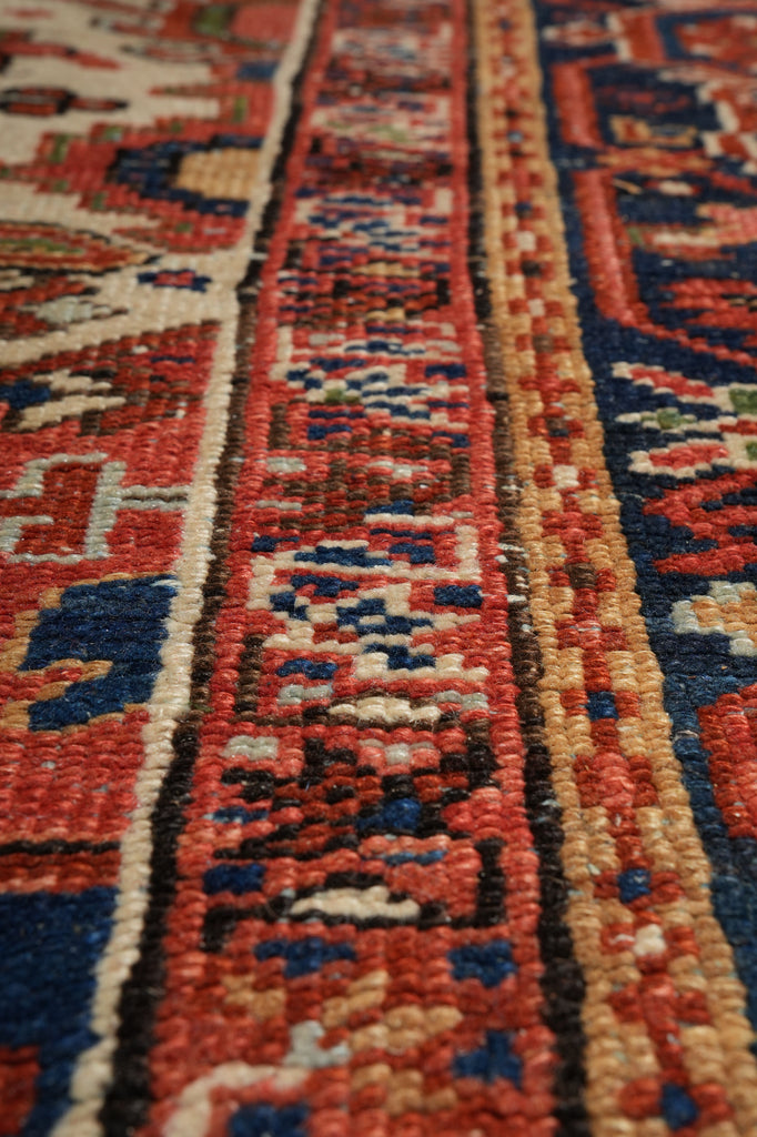 Close-up of a patterned rug with red, blue, and beige colors.