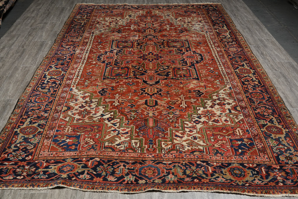 Vintage patterned rug with intricate designs on a wooden floor.