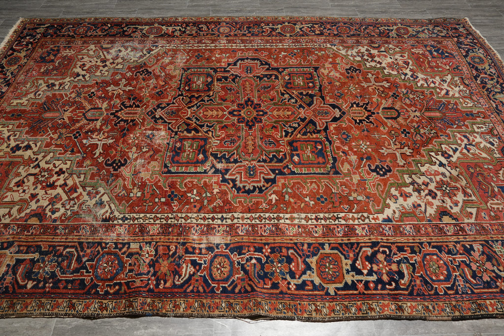 Vintage patterned rug with intricate designs on a wooden floor.