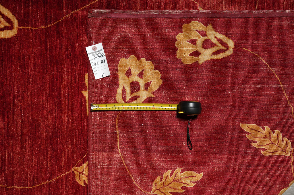 Red carpet with gold leaf patterns and a measuring tape on a red carpet background