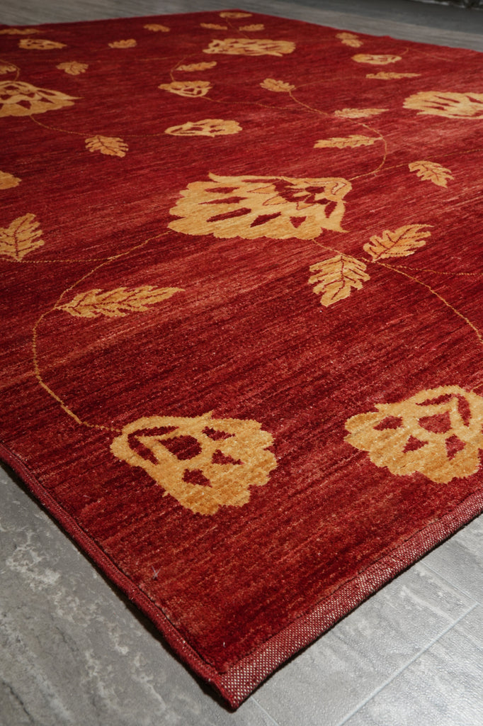 Red rug with gold leaf pattern on a gray floor