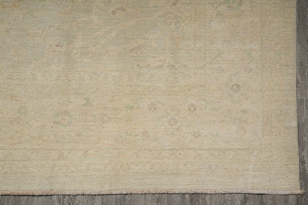Beige woven rug on a wooden floor